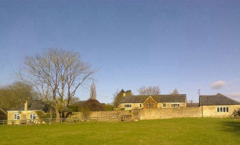 Farm buildings and open lawn near Cottisford, local community focus of Old Manor Farm